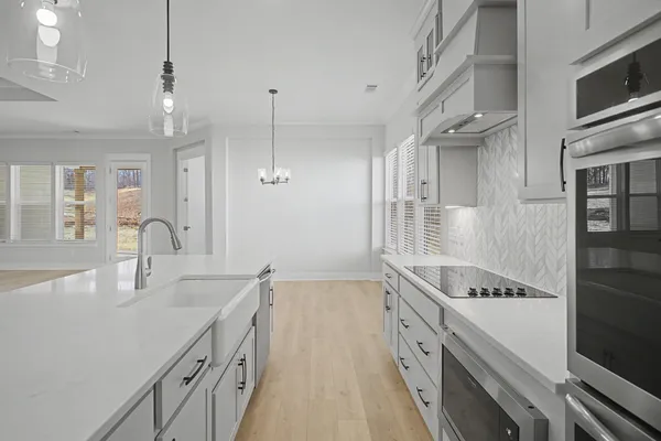 a large white kitchen with a stove sink and refrigerator