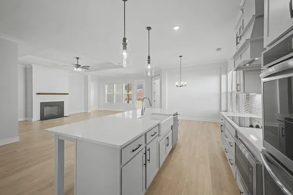 a kitchen with granite countertop white cabinets and stainless steel appliances