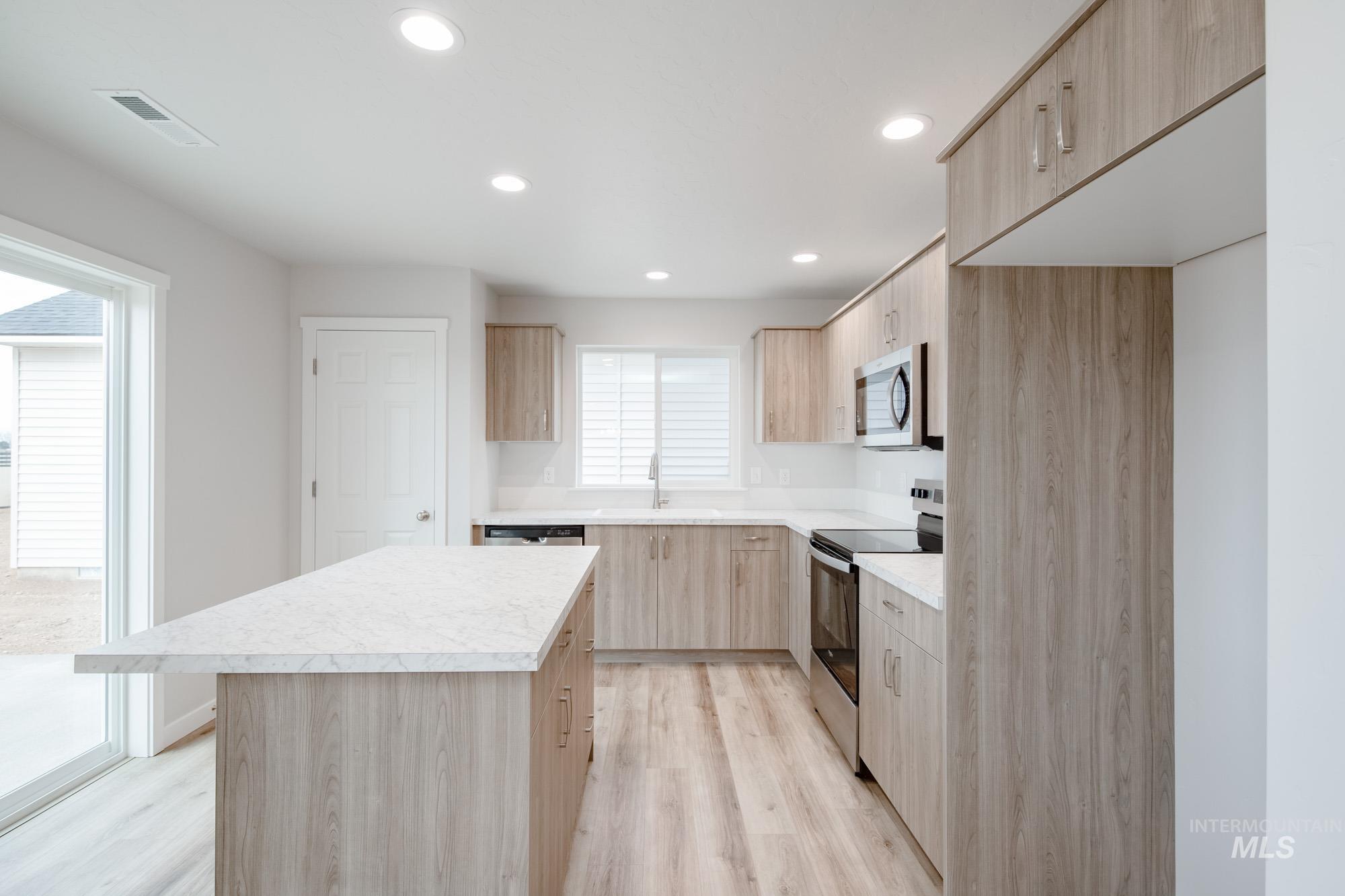 1711 North Birch Street Jerome, ID 83338 - Photo 3 of 16 Kitchen with light wood finish cabinetry, stainless steel appliances, modern cabinets, light countertops, and light wood-style flooring
