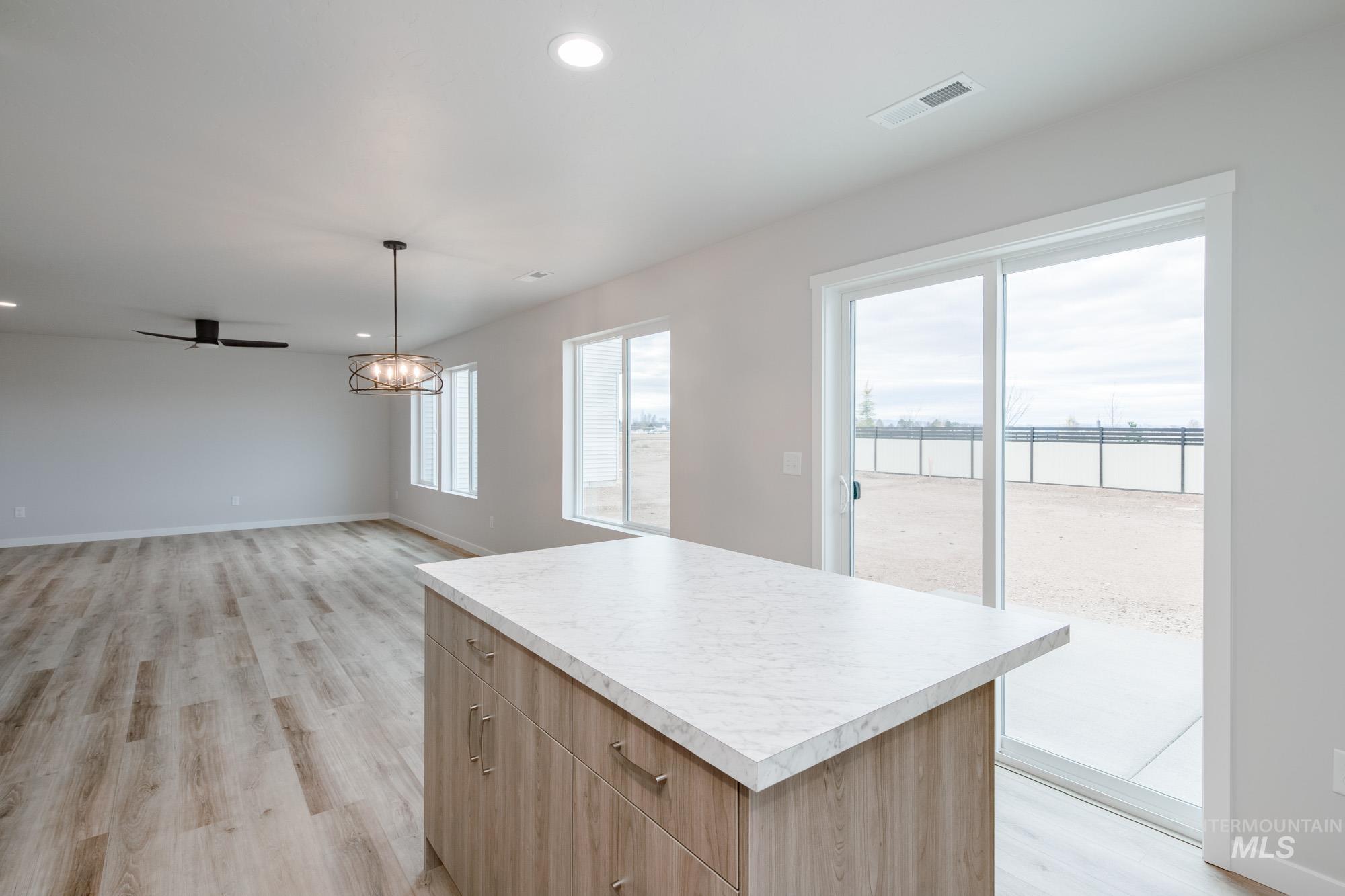 1711 North Birch Street Jerome, ID 83338 - Photo 5 of 16 Kitchen with light wood-style flooring, light countertops, a kitchen island, and hanging lights