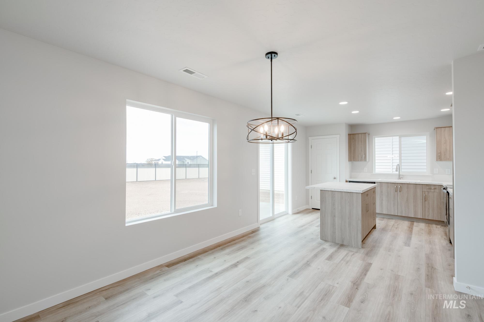 1711 North Birch Street Jerome, ID 83338 - Photo 6 of 16 Kitchen featuring hanging lights, a kitchen island, light wood finish cabinetry, light wood finished floors, and modern cabinets