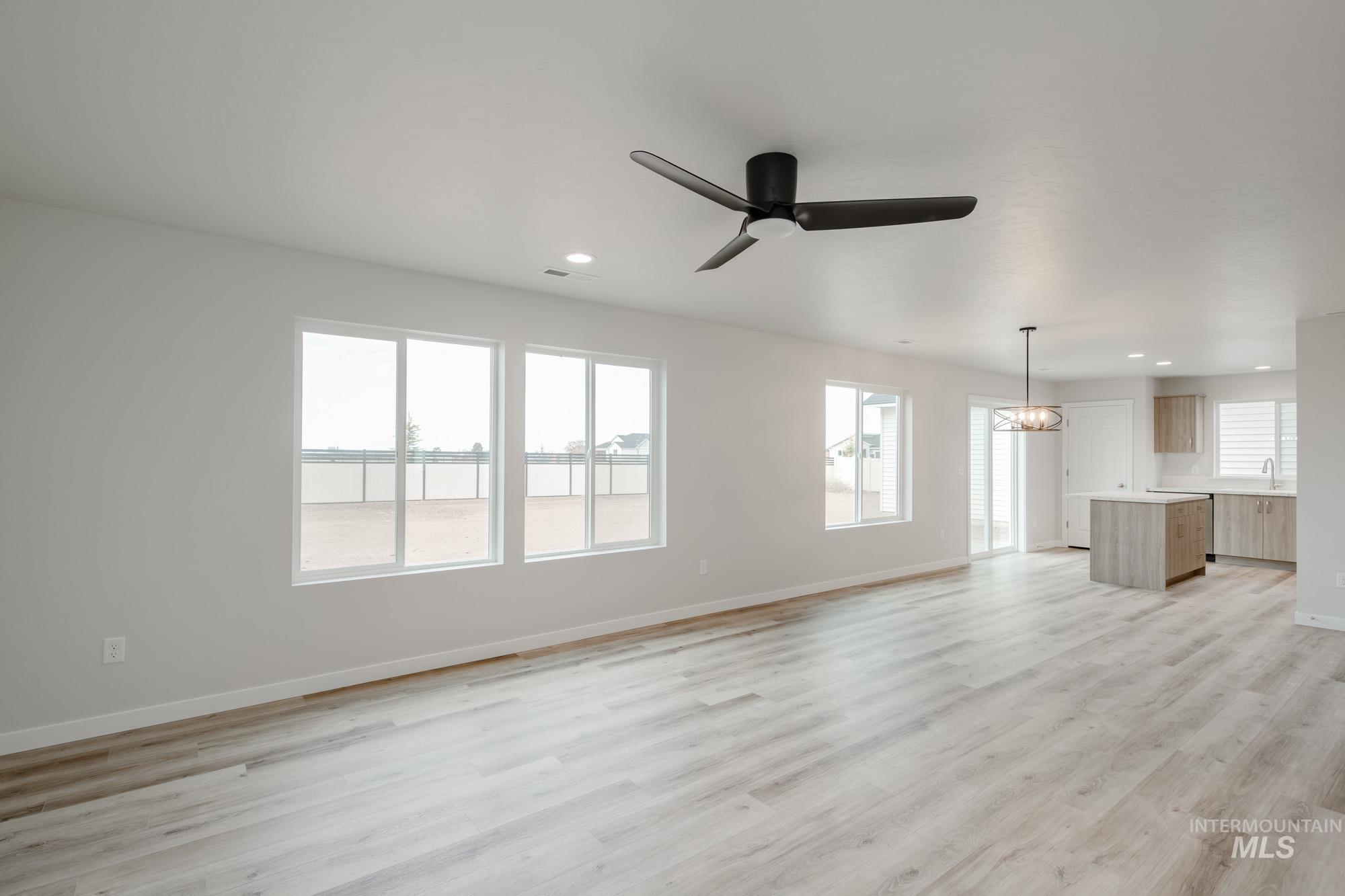 1711 North Birch Street Jerome, ID 83338 - Photo 7 of 16 Unfurnished living room with a ceiling fan, suspended lighting, and light wood-style flooring