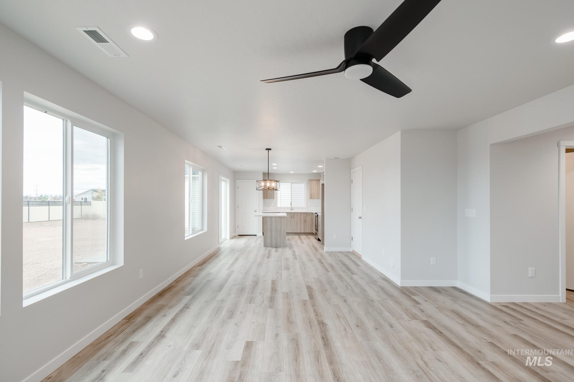 1711 North Birch Street Jerome, ID 83338 - Photo 8 of 16 Unfurnished living room with a ceiling fan, hanging lights, and light wood-style flooring