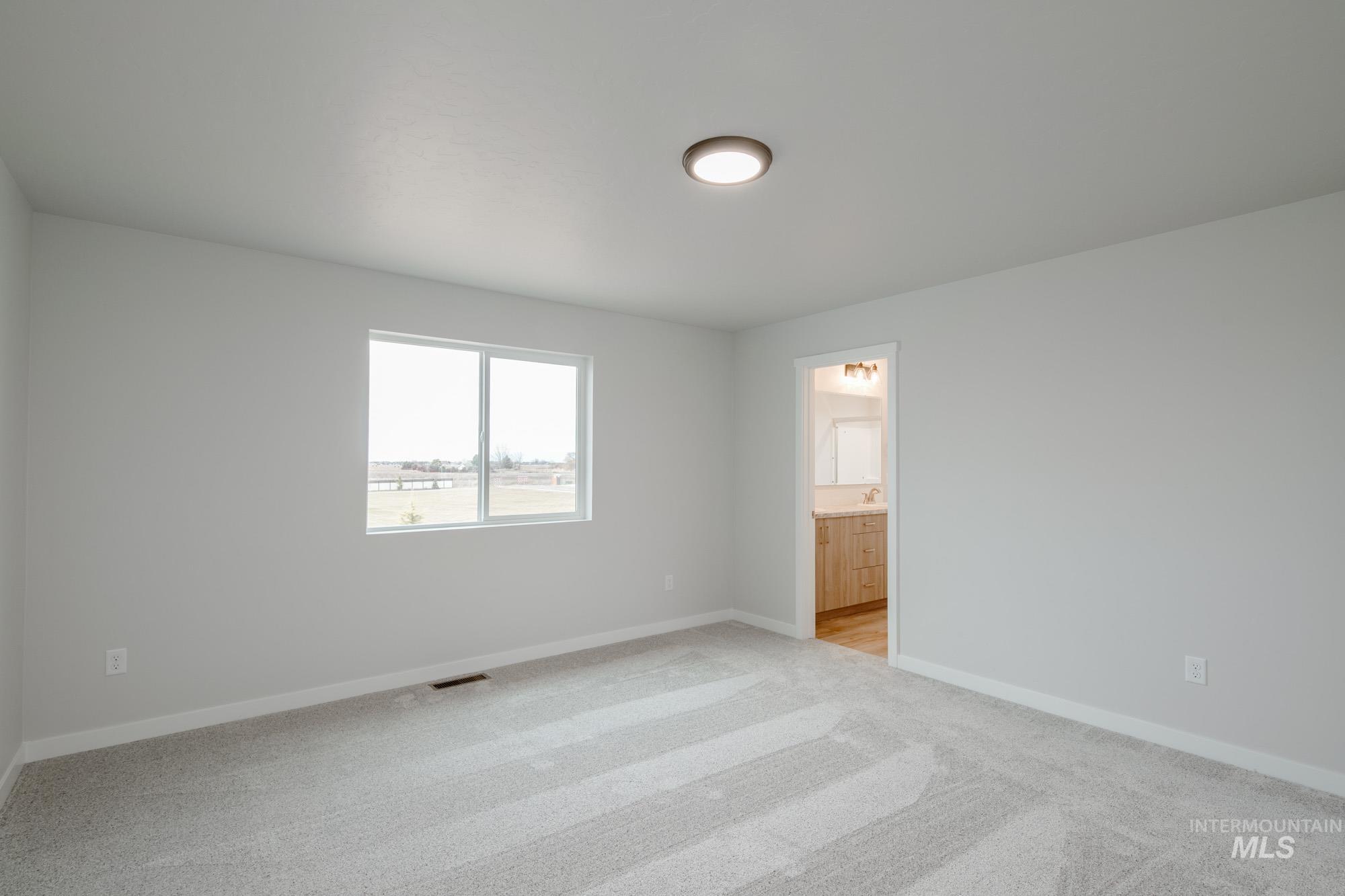 1711 North Birch Street Jerome, ID 83338 - Photo 9 of 16 Unfurnished bedroom featuring light carpet and ensuite bathroom
