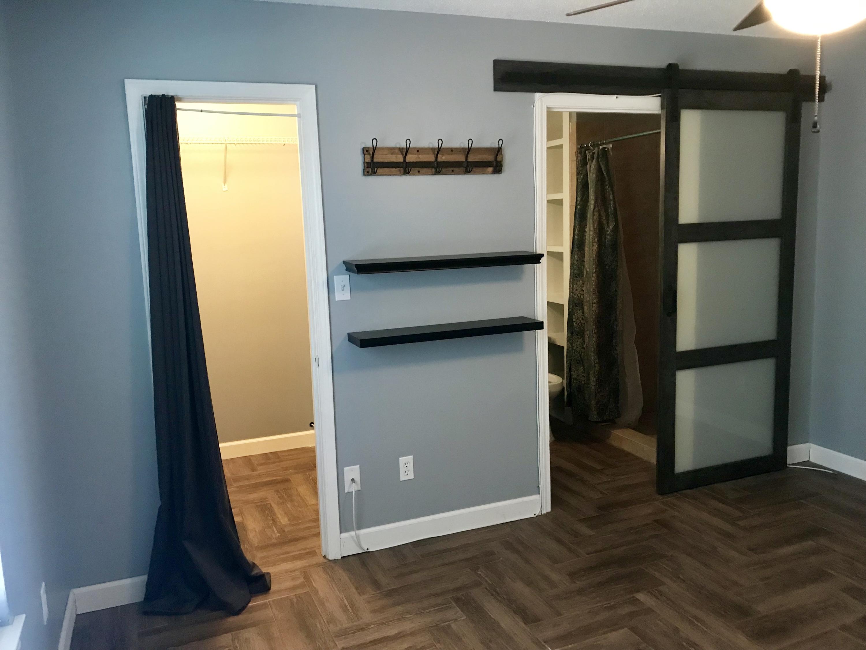 47 Ruby Circle Mary Esther, FL 32569 - Photo 11 of 30 a view of a refrigerator in kitchen and an empty room in wooden floor