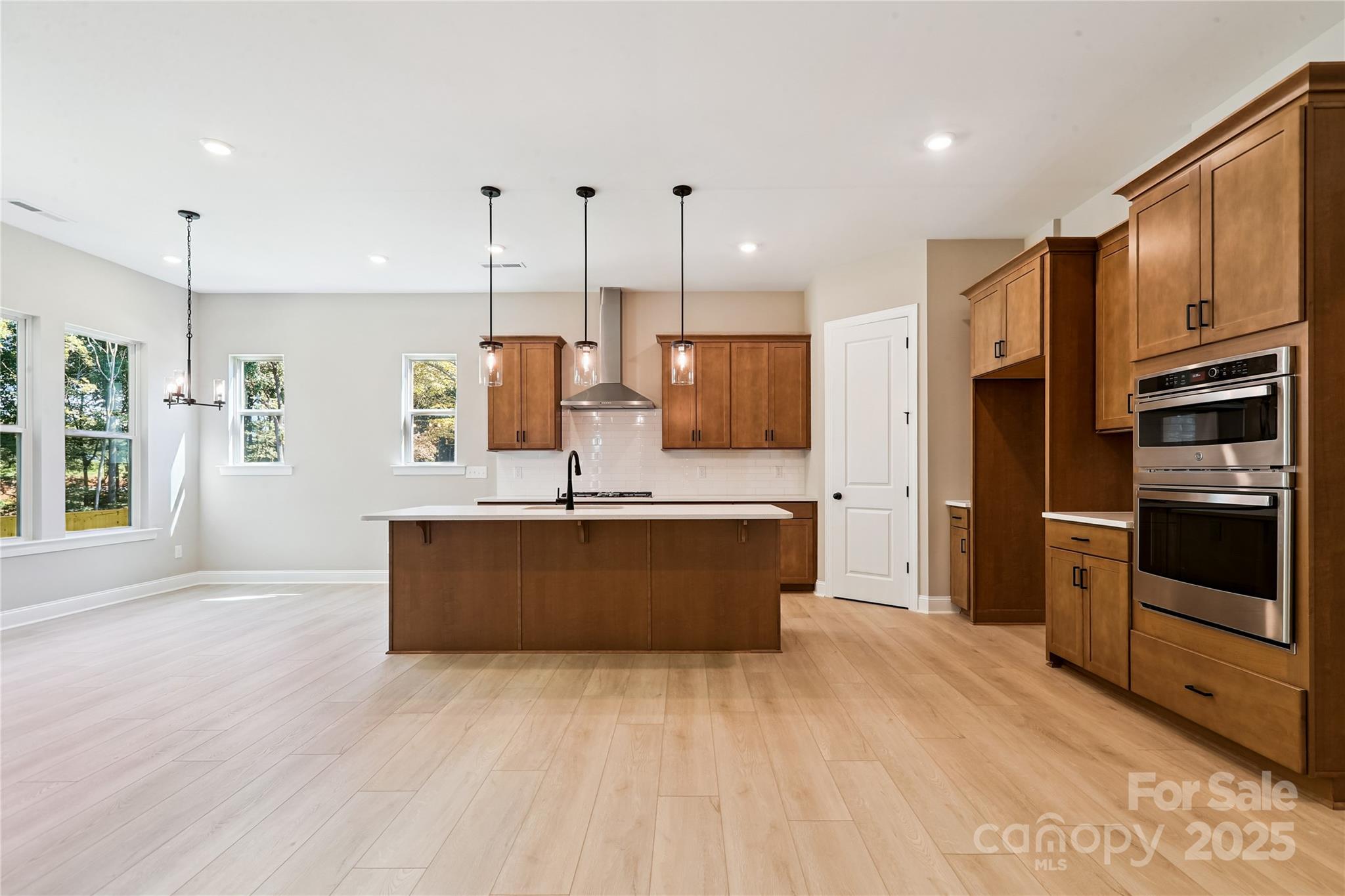 552 Fern Hill Road Mooresville, NC 28117 - Photo 3 of 12 a large kitchen with stainless steel appliances kitchen island granite countertop a stove a refrigerator a sink and a oven with large countertops