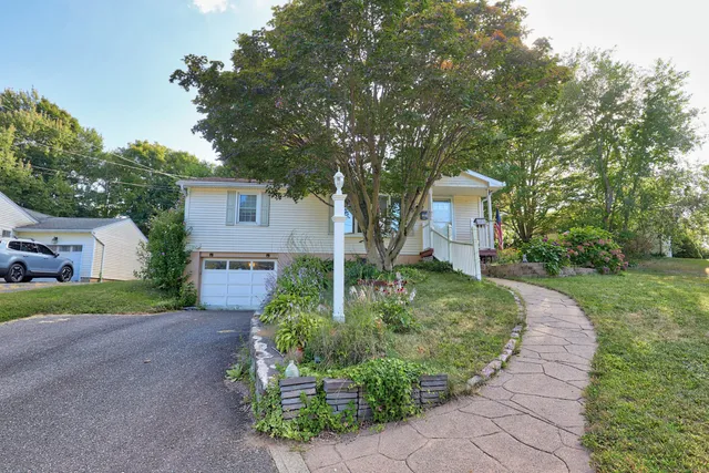 a front view of a house with a yard and trees