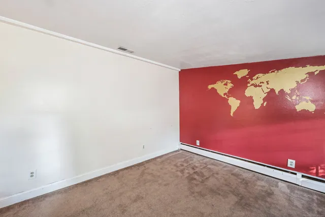 an empty room with a painting on the wall