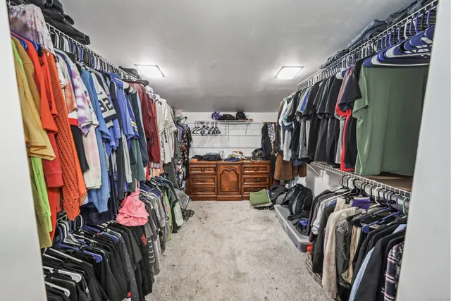 a view of walk in closet with clothes
