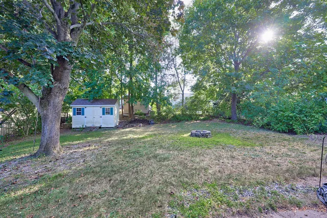a front view of a house with a garden and trees