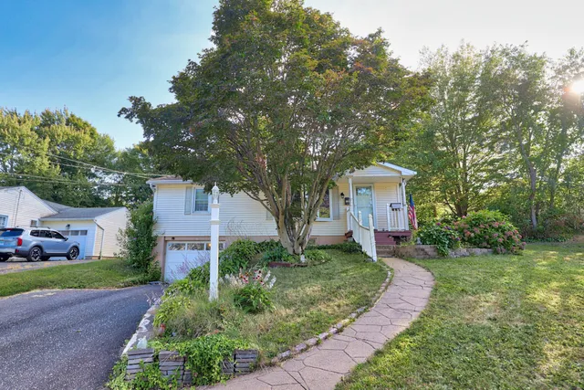 a front view of a house with a yard and trees