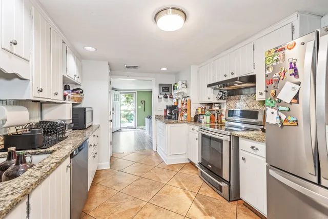 a kitchen with stainless steel appliances a stove refrigerator sink and cabinets