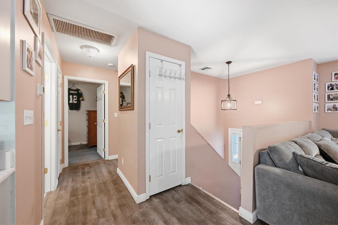 128 Chestnut Street Dingmans Ferry, PA 18328 - Photo 20 of 43 Natural wood-look flooring guides through this home's airy hallway, complemented by a contemporary hanging light fixture.