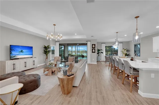 a living room with furniture a flat screen tv and a dining table with wooden floor