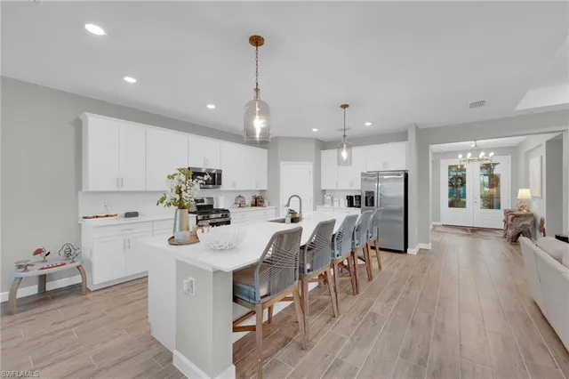 a kitchen with a dining table chairs refrigerator and cabinets