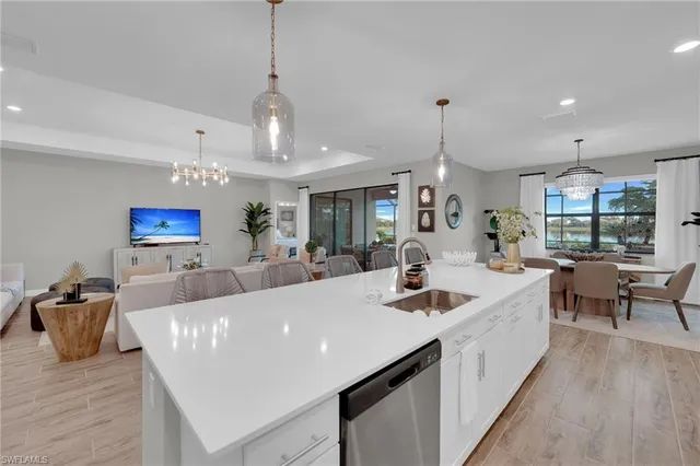 a view of a dining room and livingroom with furniture wooden floor a chandelier