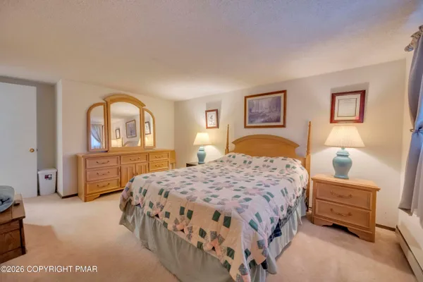 a bedroom with a bed and dresser with mirror