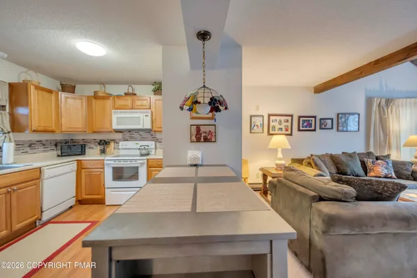 a kitchen with stainless steel appliances granite countertop a stove a sink dishwasher and a refrigerator with wooden floor