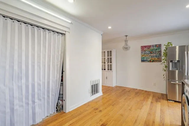 a view of a bedroom with wooden floor and a window