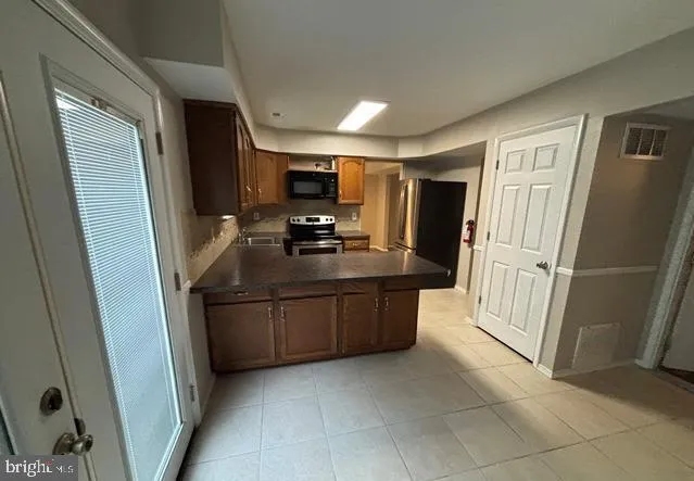 a kitchen with stainless steel appliances a refrigerator and microwave