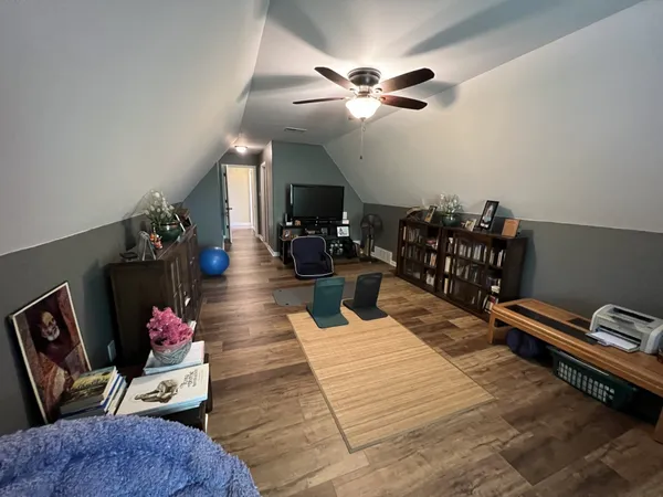 a living room with furniture flowers and a flat screen tv