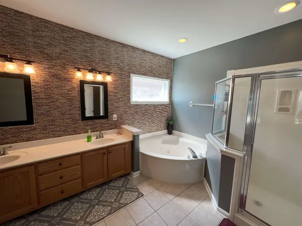 a spacious bathroom with a double vanity sink mirror and bathtub