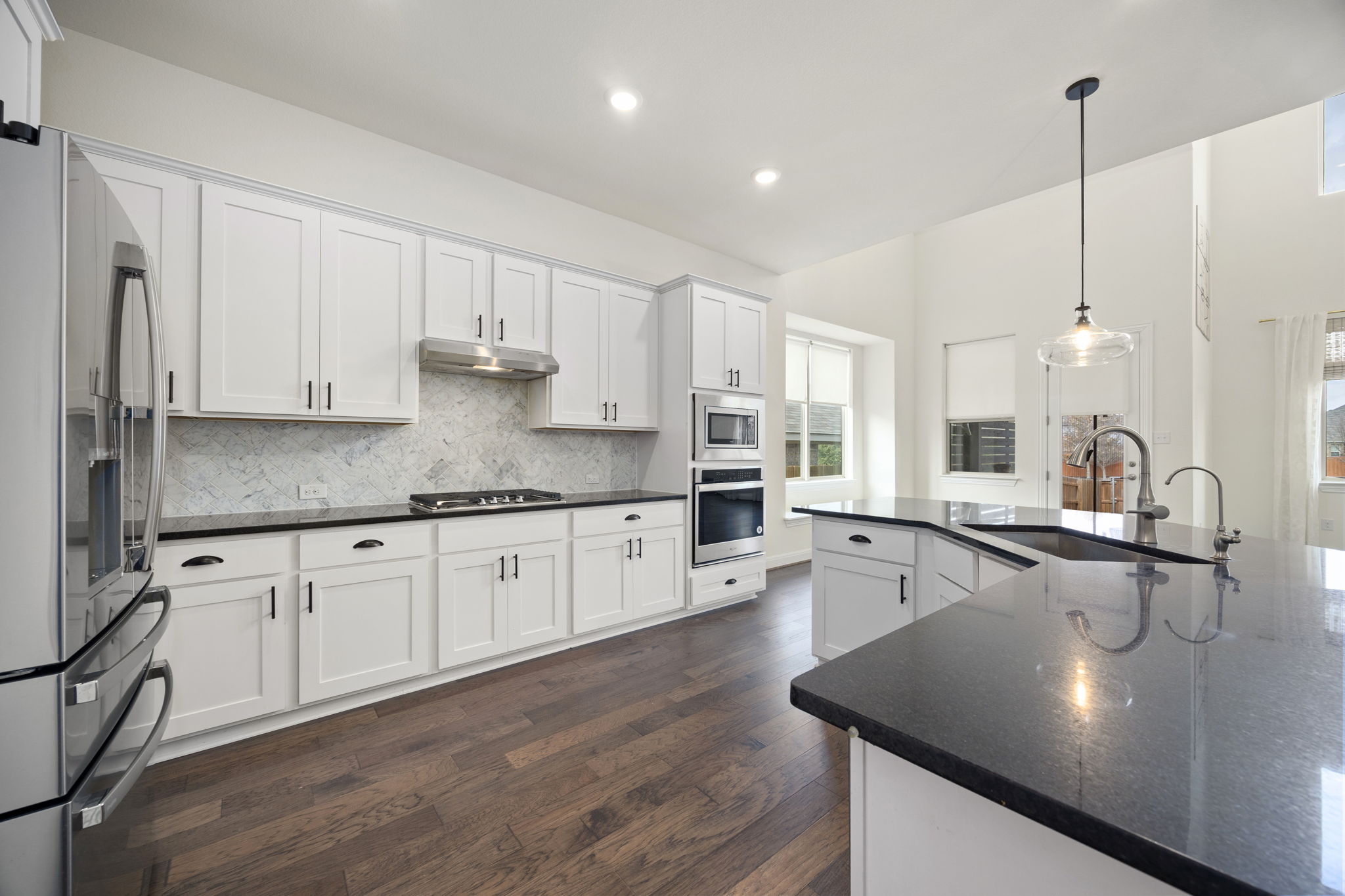 1098 Cherrystone Loop Buda, TX 78610 - Photo 1 of 37 a kitchen with stainless steel appliances granite countertop a sink a stove and white cabinets with wooden floor