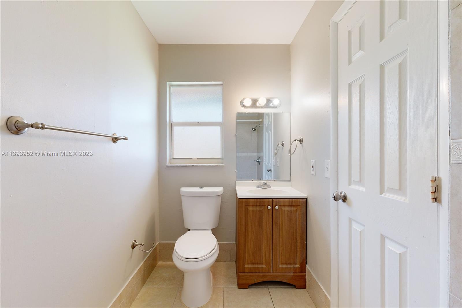 16813 Southwest 107th Place Miami, FL 33157 - Photo 13 of 28 a bathroom with a toilet a sink and mirror