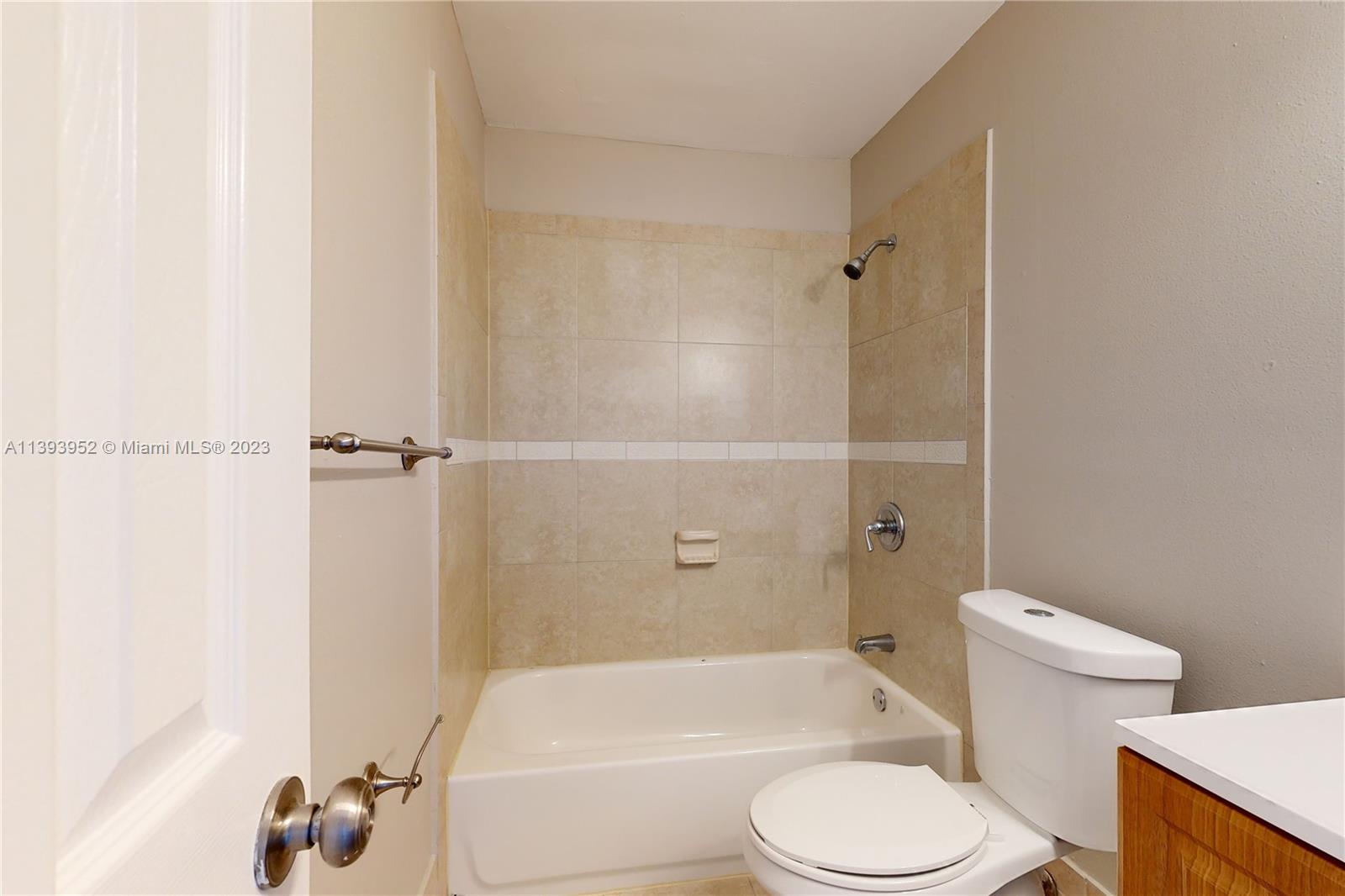 16813 Southwest 107th Place Miami, FL 33157 - Photo 18 of 28 a white toilet sitting next to a bath tub and a shower