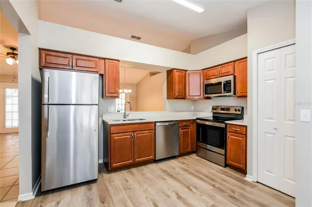 a kitchen with stainless steel appliances granite countertop a refrigerator stove top oven and sink