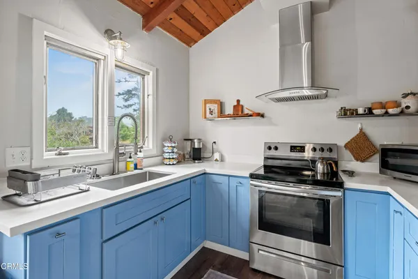 a kitchen with stainless steel appliances a stove a sink and a window