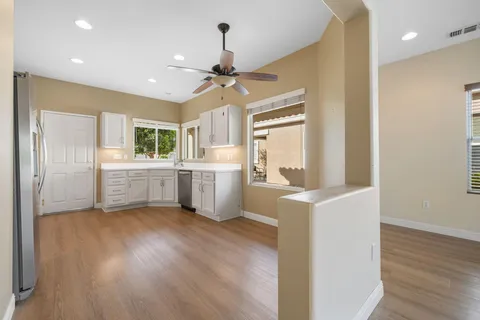 a view of a kitchen with a sink a refrigerator and a window