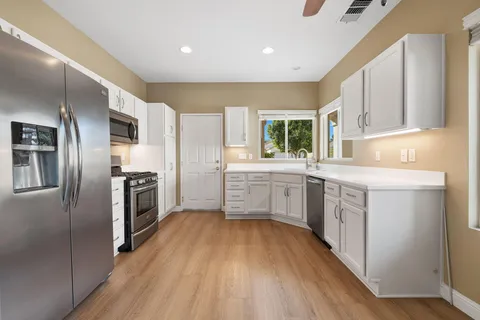 a kitchen with a refrigerator a sink a stove a microwave and cabinets