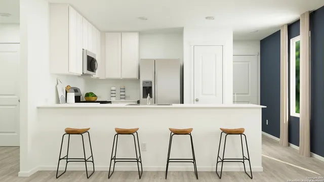 a kitchen with stainless steel appliances granite countertop white cabinets and chairs