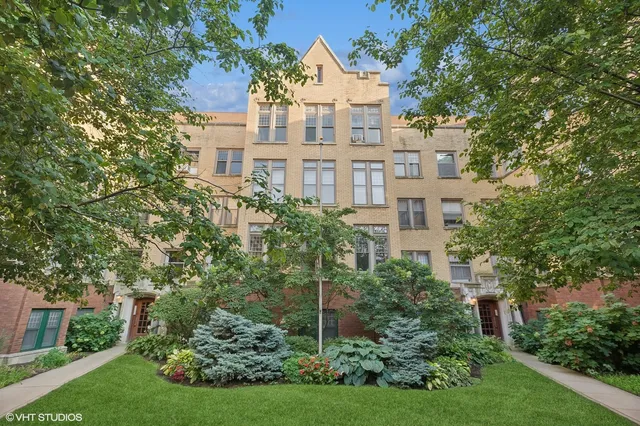 a view of a large brick building next to a yard