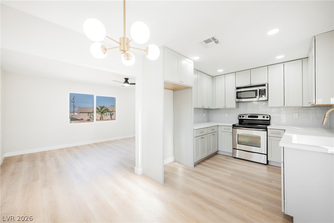 223 West Basic Road Henderson, NV 89015 - Photo 10 of 19 Gleaming wood floors connect the modern kitchen seamlessly to an open dining area.