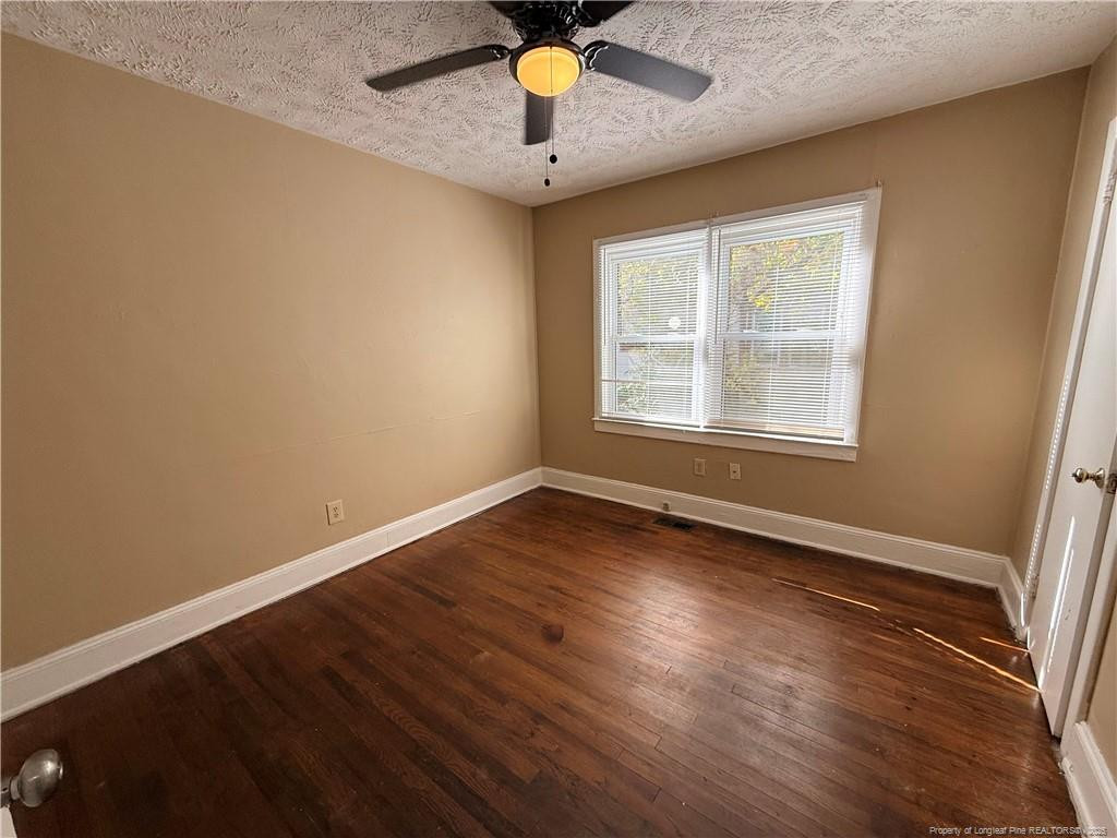 1106 Clark Street, Unit B Fayetteville, NC 28305 - Photo 5 of 12 an empty room with wooden floor and windows