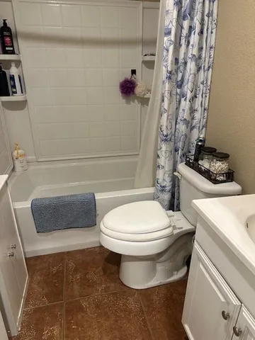 a white toilet sitting next to a bath tub