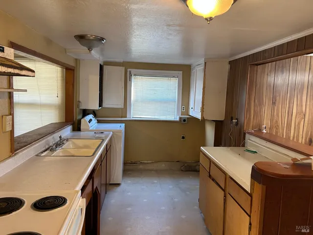 a room with a stove a sink and a refrigerator