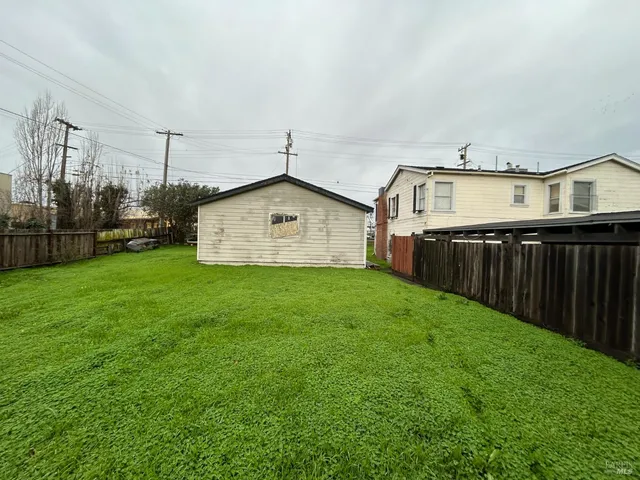 a view of a backyard with wooden fence
