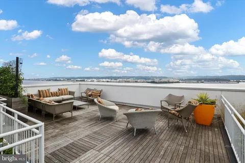 a roof deck with outdoor seating and city view
