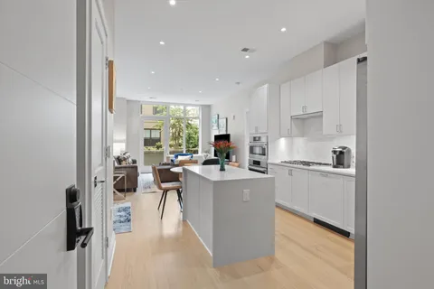 a kitchen with a sink a counter top space stainless steel appliances and cabinets