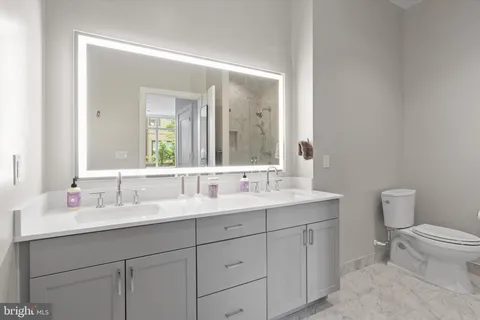 a bathroom with a toilet sink and mirror