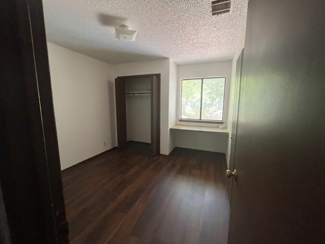 11308 Ptarmigan Drive, Unit B Austin, TX 78758 - Photo 3 of 6 an empty room with wooden floor and windows