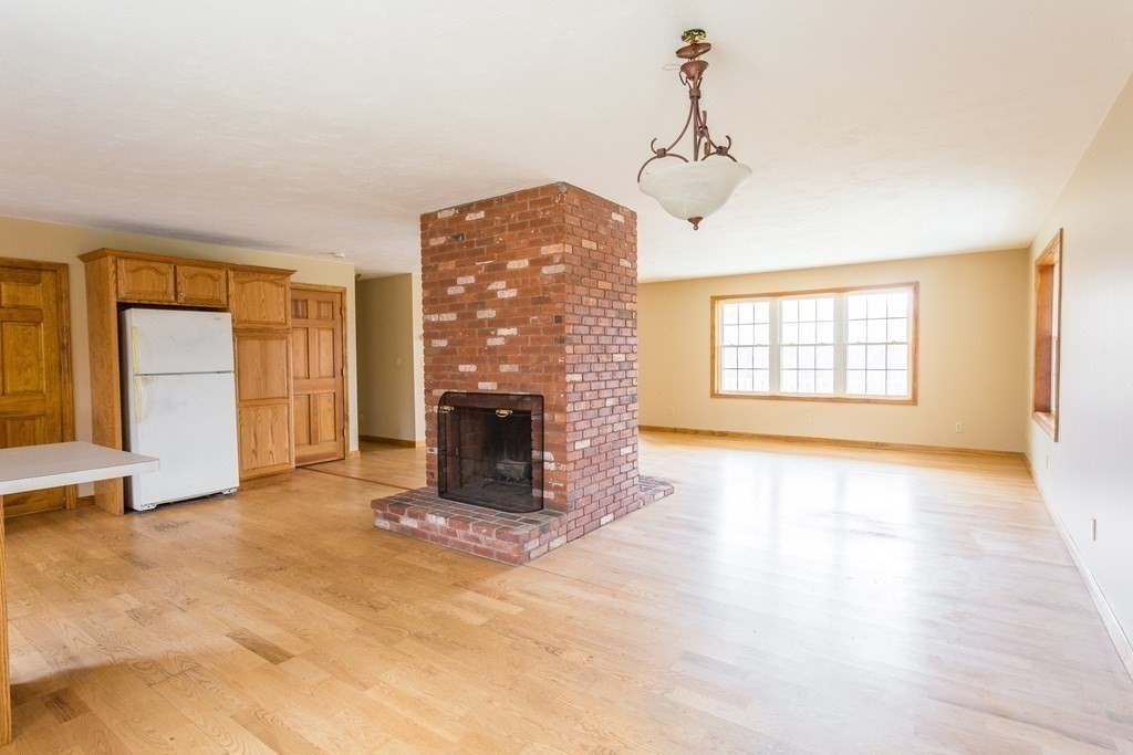 147 Ragged Hill Road West Brookfield, MA 01585 - Photo 8 of 42 an empty room with windows and fireplace