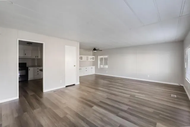 a view of empty room with wooden floor