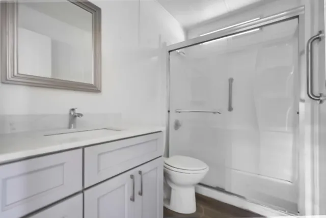 a bathroom with a granite countertop sink toilet and shower