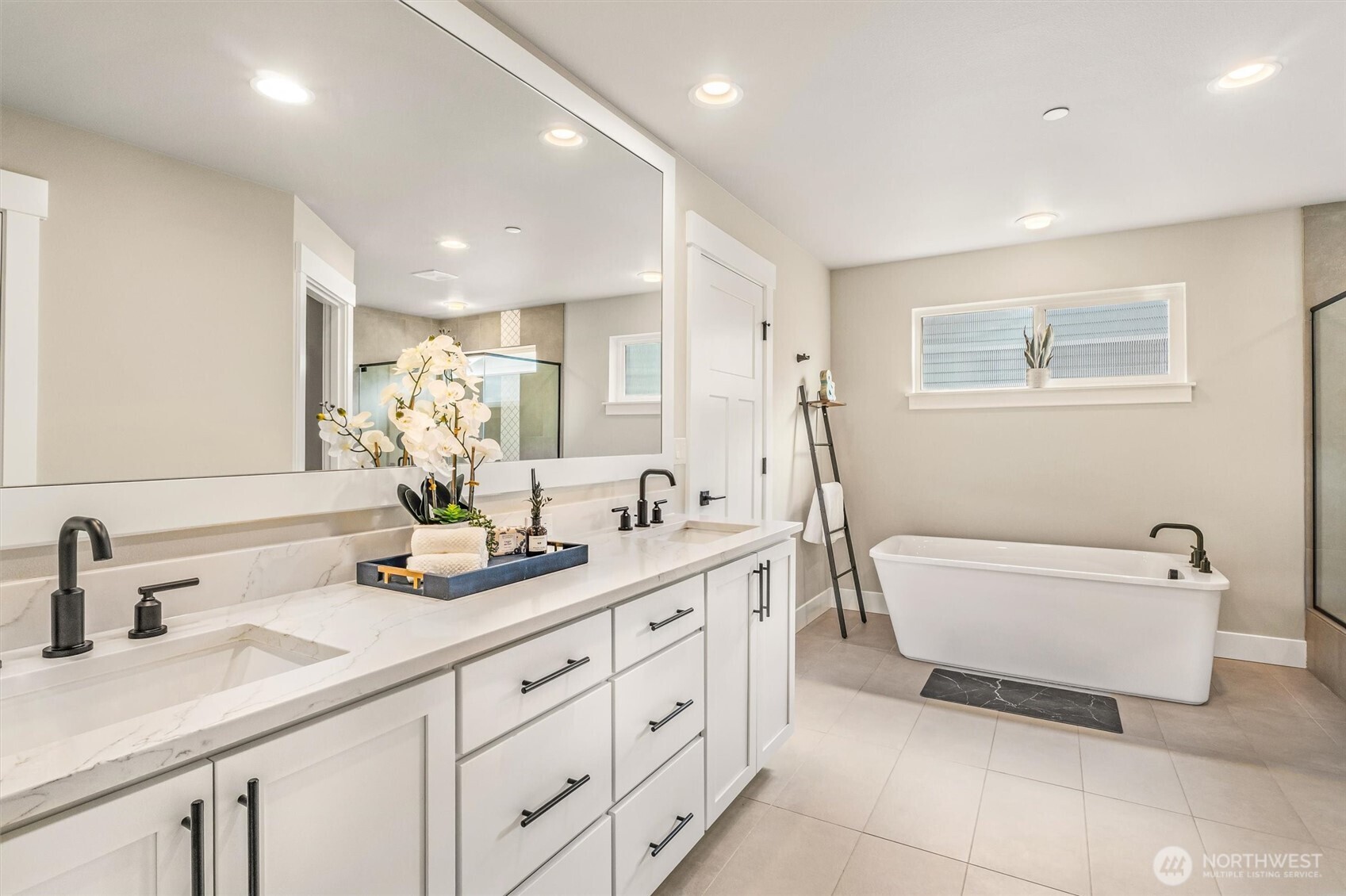 4418 242nd Place Southeast Bothell, WA 98021 - Photo 24 of 40 a spacious bathroom with a double vanity sink a mirror and a bathtub