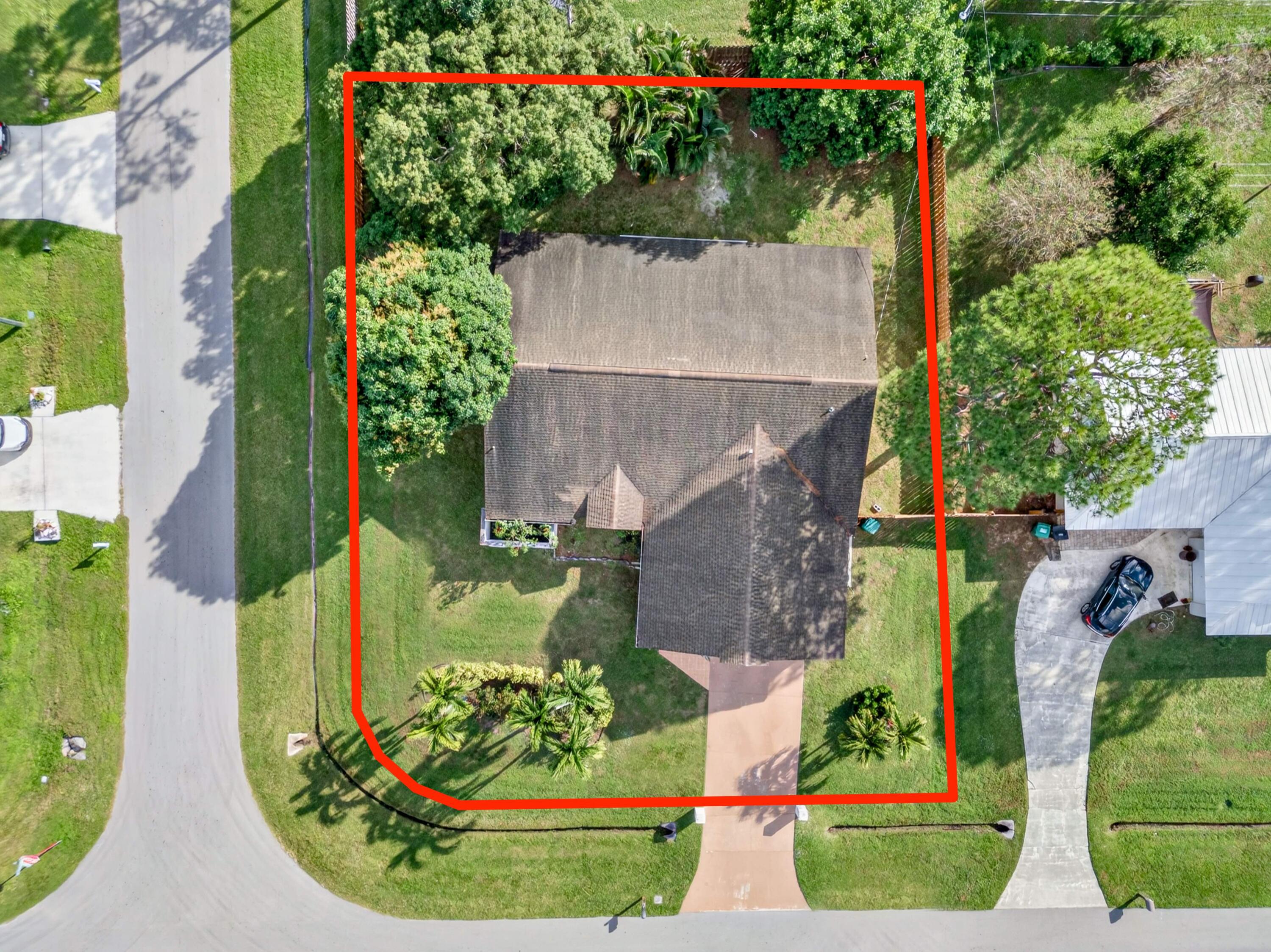 an aerial view of a house with a garden and large trees