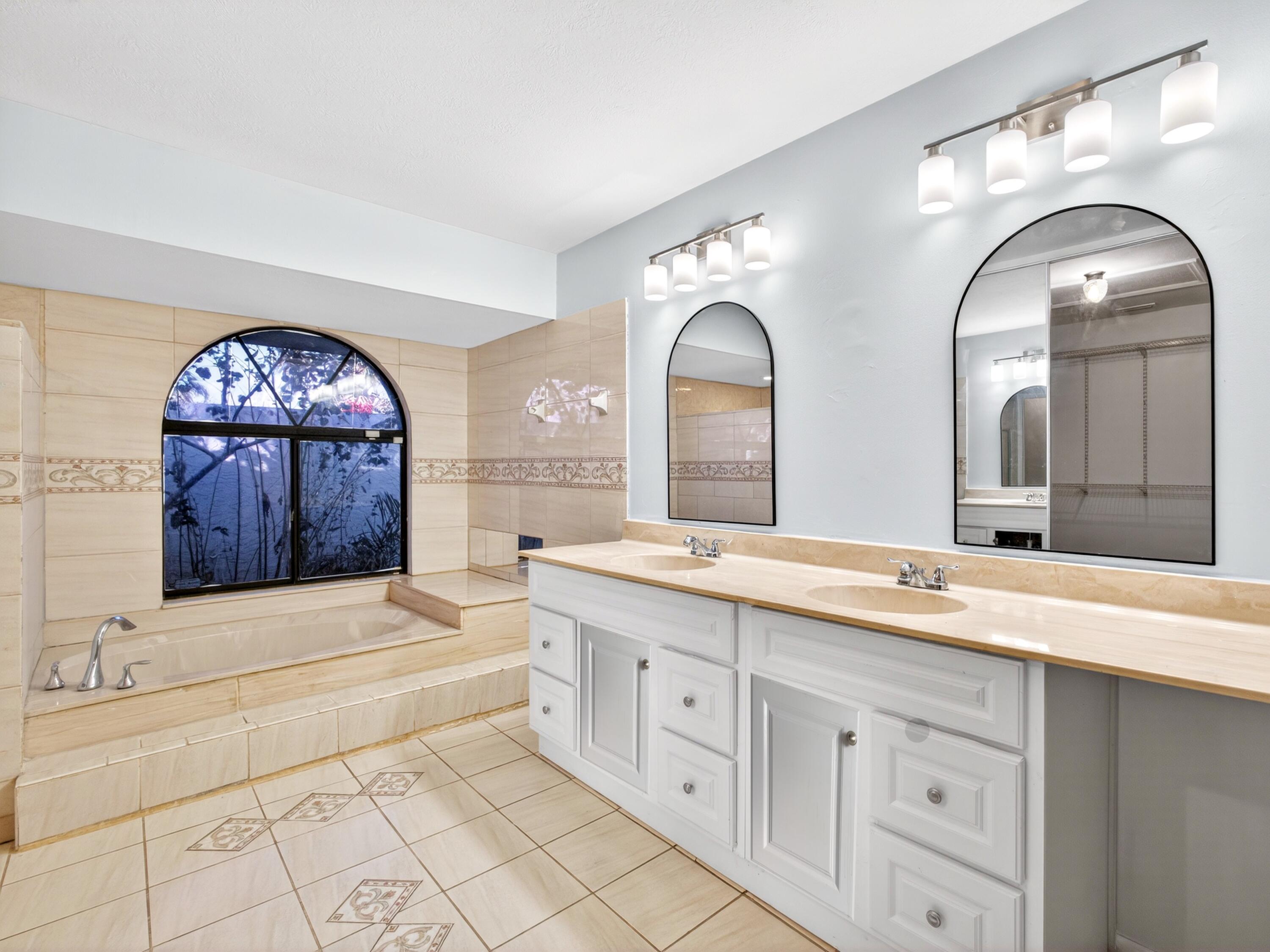 566 Southeast Damask Avenue Port St. Lucie, FL 34983 - Photo 16 of 30 a spacious bathroom with a granite countertop sink mirror and bathtub